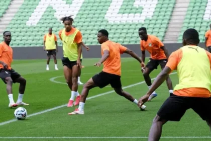 football: Joueurs ivoiriens et marocains se disputant le ballon lors d'un match amical international de haute intensité au Stade Félix Houphouët-Boigny, symbolisant les préparations stratégiques de 2026 pour la Coupe du Monde et la CAN.