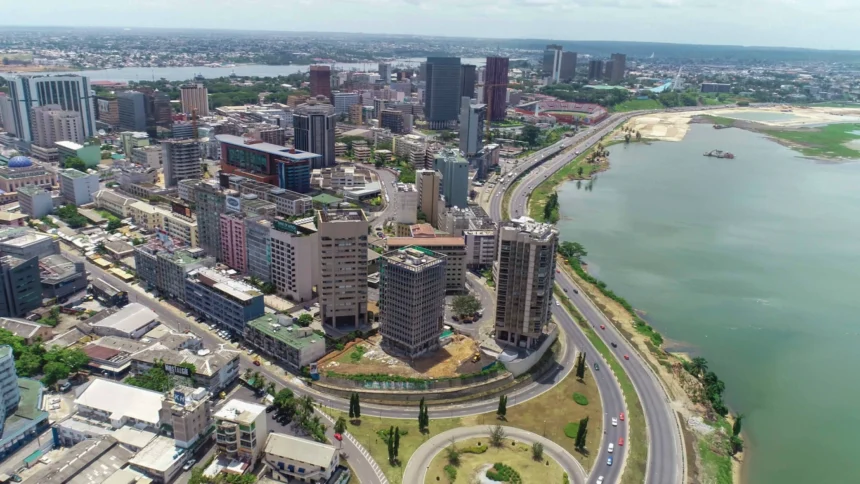 Résilience: Une vue panoramique aérienne du quartier des affaires du Plateau et de la lagune Ébrié à Abidjan en mars 2026, illustrant l'impact de la gestion stratégique des ressources des collectivités locales sur les infrastructures urbaines et le développement côtier en Côte d'Ivoire.