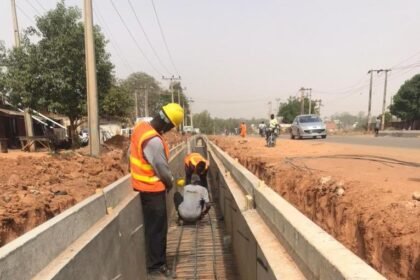 resilience.: Le ministre Amédé Kouakou Koffi et les responsables du PARU inspectant un important canal de drainage en béton en cours de construction à Abidjan en mars 2026, dans le cadre du projet de résilience urbaine visant à réduire les risques d'inondation avant la saison des pluies.