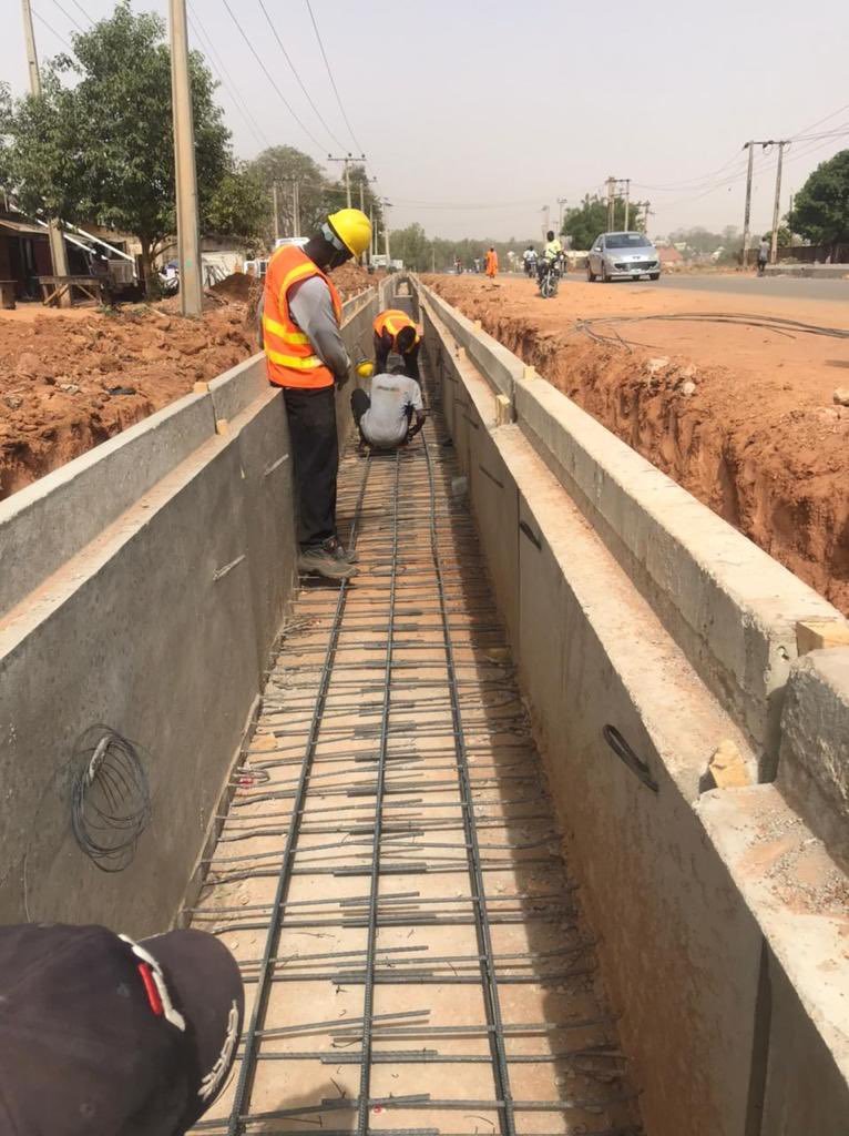 resilience.: Le ministre Amédé Kouakou Koffi et les responsables du PARU inspectant un important canal de drainage en béton en cours de construction à Abidjan en mars 2026, dans le cadre du projet de résilience urbaine visant à réduire les risques d'inondation avant la saison des pluies.