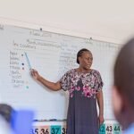 Éducation : un enseignant debout devant un tableau noir dans une salle de classe au Zimbabwe, illustrant l'effort national plus large de 2026 pour recruter 8 000 éducateurs et pourvoir 2 000 postes d'enseignement scientifique critiques afin de soutenir l'initiative Éducation 5.0.