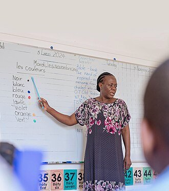 Éducation : un enseignant debout devant un tableau noir dans une salle de classe au Zimbabwe, illustrant l'effort national plus large de 2026 pour recruter 8 000 éducateurs et pourvoir 2 000 postes d'enseignement scientifique critiques afin de soutenir l'initiative Éducation 5.0.