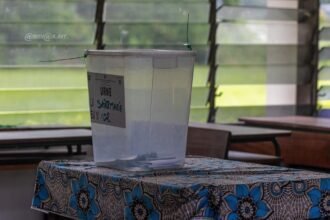 élection: Un agent de bureau de vote en Côte d'Ivoire préparant une urne, représentant le cycle des élections législatives 2025-2026 et la proclamation consécutive d'une majorité de 197 sièges pour le RHDP à l'Assemblée Nationale.