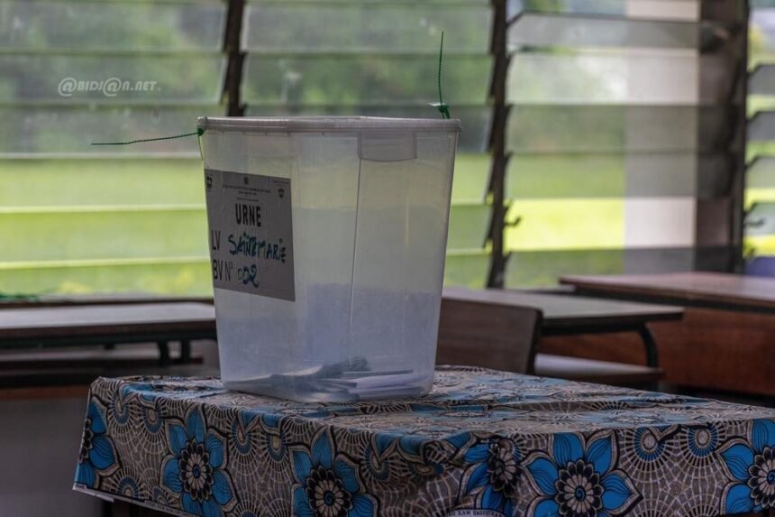 élection: Un agent de bureau de vote en Côte d'Ivoire préparant une urne, représentant le cycle des élections législatives 2025-2026 et la proclamation consécutive d'une majorité de 197 sièges pour le RHDP à l'Assemblée Nationale.