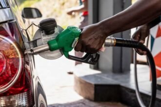 Stabilité des Prix: Un gros plan d'un pistolet de carburant et d'un affichage numérique dans une station-service ivoirienne en avril 2026, représentant la décision du gouvernement de maintenir des prix stables pour le super (820 FCFA) et le gasoil (675 FCFA) malgré la hausse des cours mondiaux du pétrole.