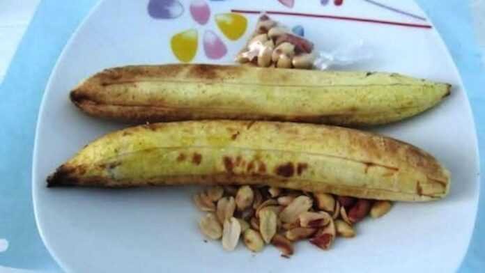 snack: Des arachides de haute qualité exposées dans un panier traditionnel tressé sur un marché local ivoirien, en mars 2026, représentant l'accent stratégique du gouvernement sur la souveraineté alimentaire et la modernisation de la chaîne de valeur agricole dans le cadre du PND 2026-2030.