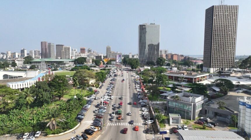 MMA: Une vue panoramique de la ligne d'horizon d'Abidjan dans le quartier du Plateau, présentant des gratte-ciels modernes et la lagune Ébrié, symbolisant la transformation économique et la croissance industrielle de la Côte d'Ivoire en 2026.