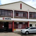 restructuration: Une vue extérieure de l'entrepôt et du siège social de Würth Kenya à Nairobi, arborant le logo rouge et blanc distinctif de Würth, représentant les près de 30 ans de présence de l'entreprise dans le secteur industriel d'Afrique de l'Est.